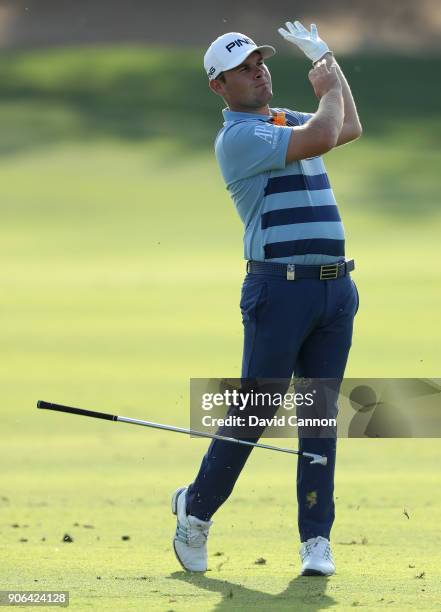 Tyrrell Hatton of England reacts to his second shot on the par 4, 17th hole during the first round of the 2018 Abu Dhabi HSBC Golf Championship at...