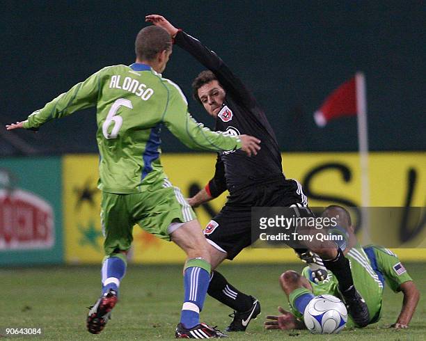 Ben Olsen of D.C. United gets caught between Osvaldo Alonso and Peter Vagenas of Seattle Sounders FC during an MLS match at RFK Stadium on September...