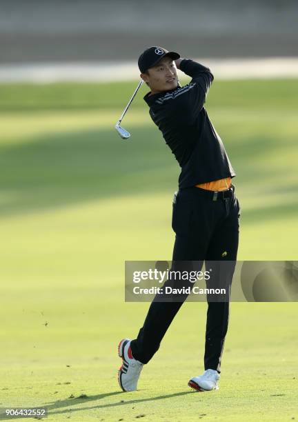 Haotong Li of China plays his second shot on the par 4, 17th hole during the first round of the 2018 Abu Dhabi HSBC Golf Championship at the Abu...