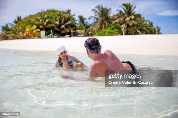 father and daughter enjoying a family vacation on idyllic beach in maldives atoll - bikini atoll stockfoto's en -beelden