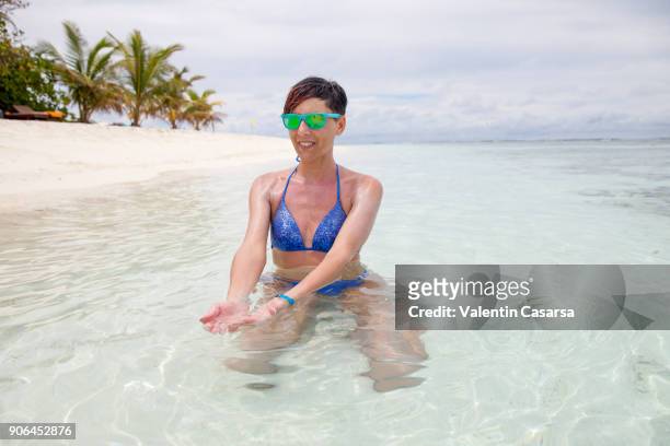 adult woman enjoying a vacation on a tropical maldives atoll - bikini atoll stockfoto's en -beelden