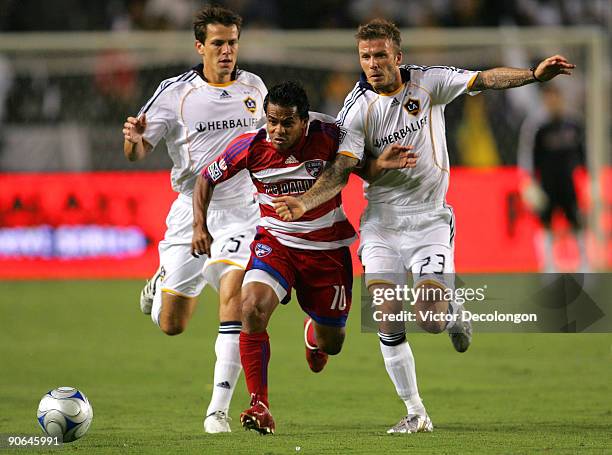 David Ferreira of FC Dallas paces the ball past Stefani Miglioranzi and David Beckham of the Los Angeles Galaxy in the first half during the MLS...