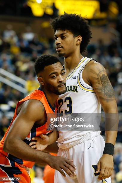 Michigan Wolverines guard Ibi Watson is guarded by Illinois Fighting Illini guard Mark Alstork during a regular season Big 10 Conference basketball...