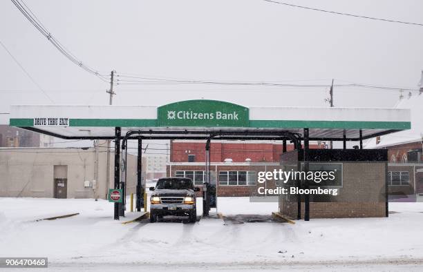 Customer uses the drive through teller lane at a Citizens Financial Group Inc. Bank branch as snow falls in downtown Portsmouth, Ohio, U.S., on...