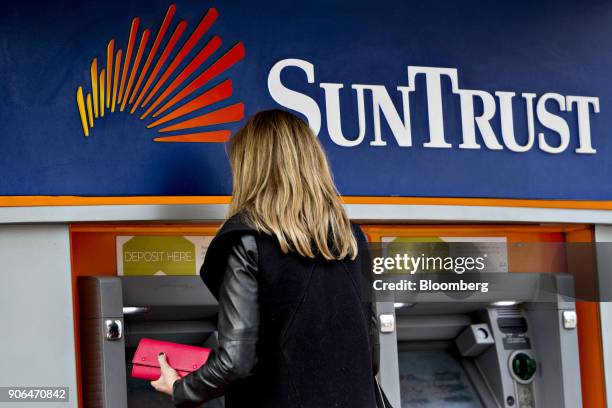 Customer uses an automatic teller machine at a SunTrust Banks Inc. Branch in Washington, D.C., U.S., on Thursday, Jan. 11, 2018. SunTrust Banks Inc....