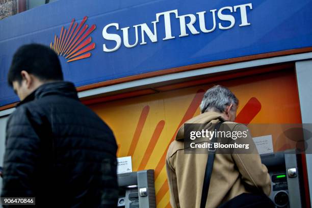 Customer uses an automatic teller machine at a SunTrust Banks Inc. Branch in Washington, D.C., U.S., on Thursday, Jan. 11, 2018. SunTrust Banks Inc....