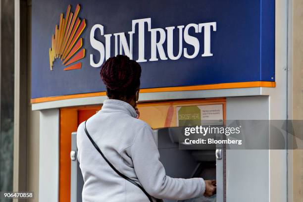 Customer uses an automatic teller machine at a SunTrust Banks Inc. Branch in Washington, D.C., U.S., on Thursday, Jan. 11, 2018. SunTrust Banks Inc....