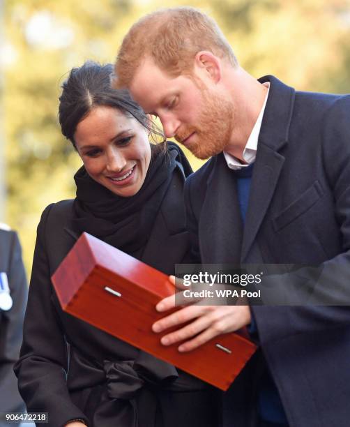 Prince Harry and his fiancee Meghan Markle open a wedding gift from Harry Smith and Megan Taylor, both from Marlborough Primary School, during their...