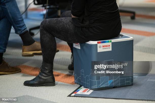 An attendee sits on a Bosch #streetflow e-bike branded stool as Robert Bosch GmbH opens an Internet of Things campus in Berlin, Germany, on Thursday,...