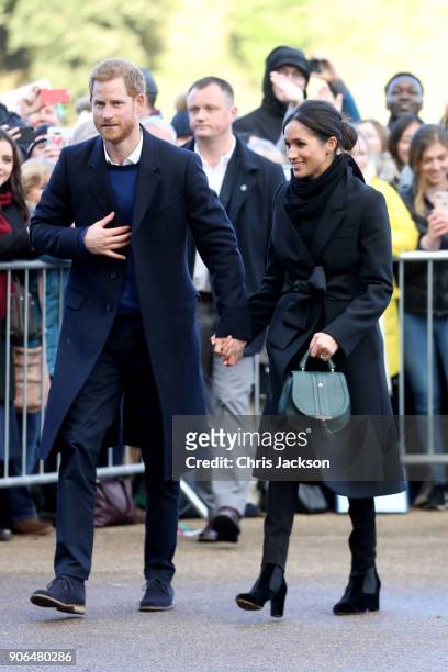 Prince Harry and his fiancee Meghan Markle are seen holding hands during a walkabout at Cardiff Castle on January 18, 2018 in Cardiff, Wales.