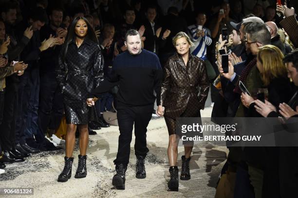 British designer Kim Jones holds hands with British models Naomi Campbell and Kate Moss as he acknowledges the public at the end of the Louis Vuitton...