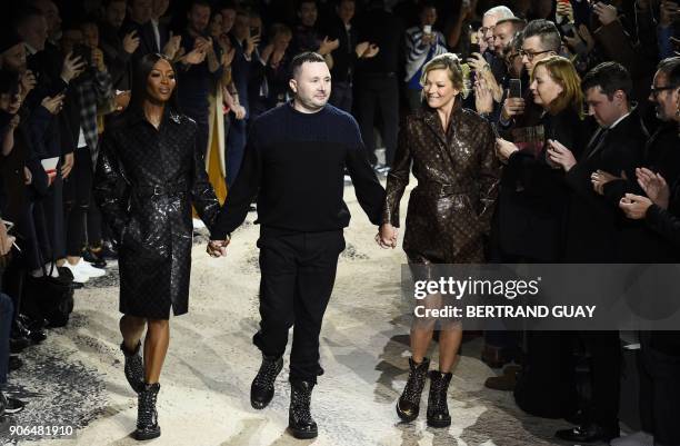 British designer Kim Jones holds hands with British models Naomi Campbell and Kate Moss as he acknowledges the public at the end of the Louis Vuitton...