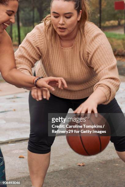 Two Young Women Playing Basketball