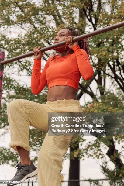 young woman on pull up bar - chin ups stockfoto's en -beelden