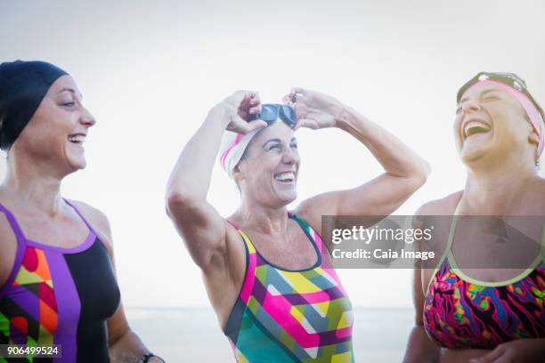 laughing female open water swimmers - weichzeichner stock-fotos und bilder