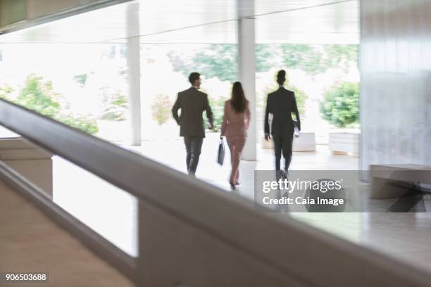 pensive businessman looking away at modern office window - portrait of pensive young businessman wearing glasses stock-fotos und bilder