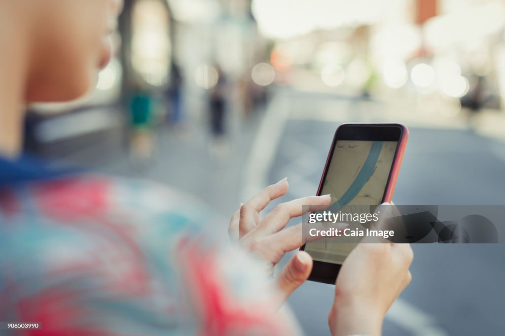 Close up woman using smart phone GPS on street
