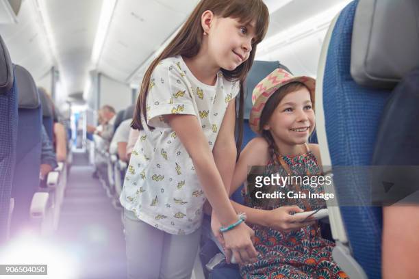 girl sisters playing video game on airplane - girls trip film stockfoto's en -beelden
