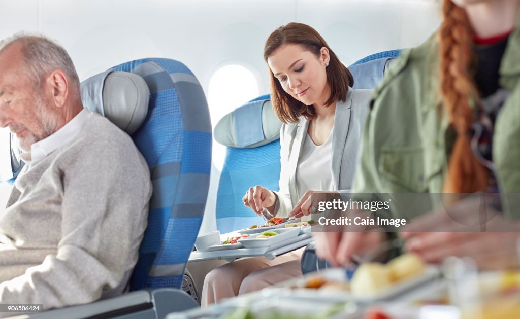 Woman eating dinner on airplane