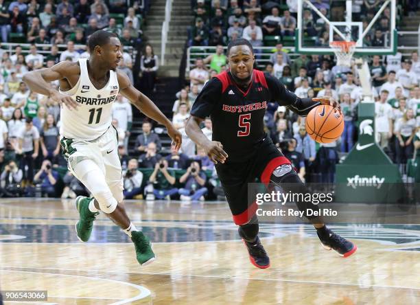 Mike Williams of the Rutgers Scarlet Knights drives to the basket while defended by Lourawls Nairn Jr. #11 of the Michigan State Spartans during a...