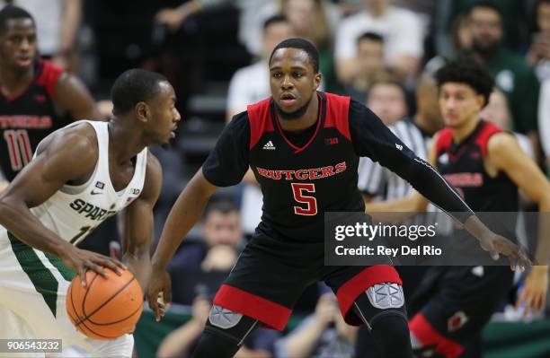 Lourawls Nairn Jr. #11 of the Michigan State Spartans handles the ball while defended by Mike Williams of the Rutgers Scarlet Knights at Breslin...