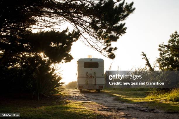rear view of campervan with christmas deco parked on beach in golden sunset light, west coast - nordinsel von neuseeland stock-fotos und bilder