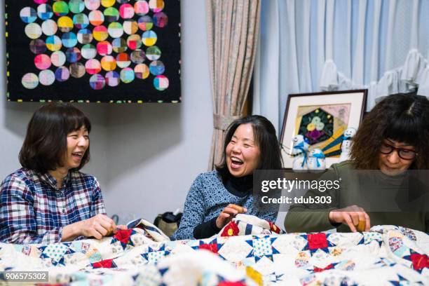 senior women working together to make a patchwork quilt - patchwork stock pictures, royalty-free photos & images