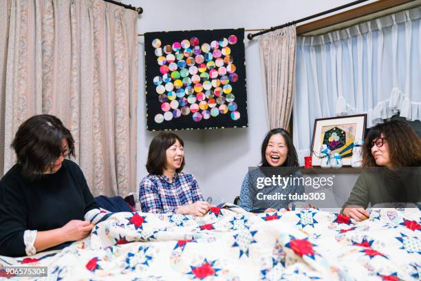 senior women working together to make a patchwork quilt - patchwork stock pictures, royalty-free photos & images