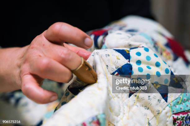 a close-up shot of a senior woman sewing and making crafts in her home - patchwork hands stock pictures, royalty-free photos & images