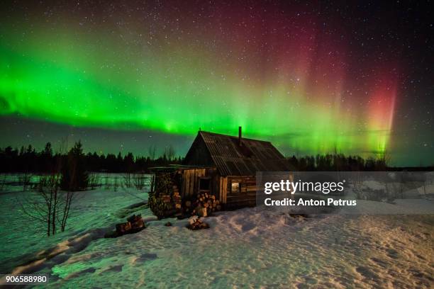 northern lights above a wooden house - northern mariana islands stock-fotos und bilder