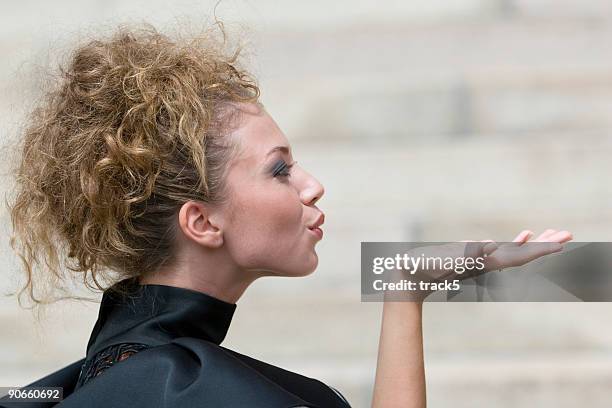 vista laterale di una bella donna modello mandare un bacio - mandare un bacio foto e immagini stock