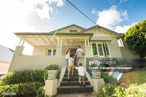 multi-cultural family in australia enters and exits their house - coming home front door stock-fotos und bilder