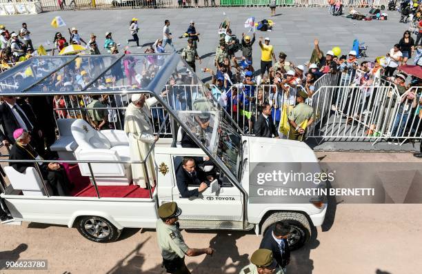 Pope Francis waves from the popemobile after celebrating an open-air mass at Lobitos Beach, near the northern Chilean city of Iquique, on January 18,...