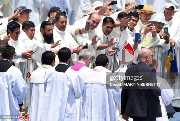 Religious men waves at Pope Francis as he leaves after celebrating an open-air mass at Lobitos Beach, near the northern Chilean city of Iquique, on...
