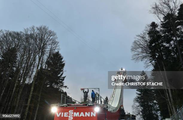 Officials work on the ski jump as the qualifying round of the ski-flying World Championship has been cancelled due to strong winds on January 18,...