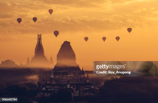 scenery view of hot air balloons flying over the ancient temple in bagan during the sunrise. the temple is still repairing after damaged from the 2016 big earthquake. - bagan temples damaged in myanmar earthquake stock pictures, royalty-free photos & images