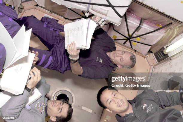Cosmonaut Yuri I. Malenchenko, bottom left, and astronauts Edward T. Lu, bottom right and Terrence W. Wilcutt float inside the United States built...