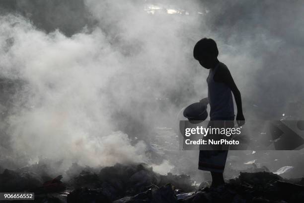 Residents scavenge whats left of houses after a fire broke out in Taguig City, south of Manila,Philippines, on Thursday, 18 January 2018. The fire...