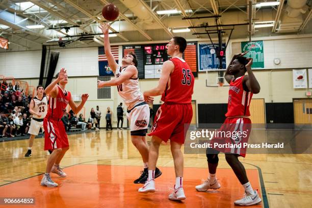 Biddefords Carter Edgerton puts up a shot as Scarborough defenders, from left, Alexander Austin, Nick Fiorillo, and Jaquan Seme look on during their...