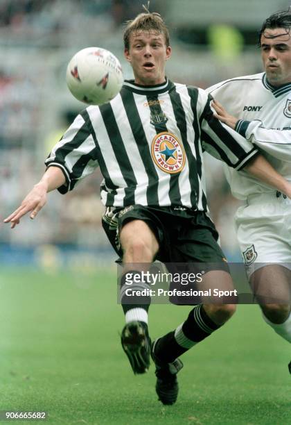 Jon Dahl Tomasson of Newcastle United holds off Stephen Carr of Tottenham Hotspur during an FA Carling Premiership match at St James' Park on October...