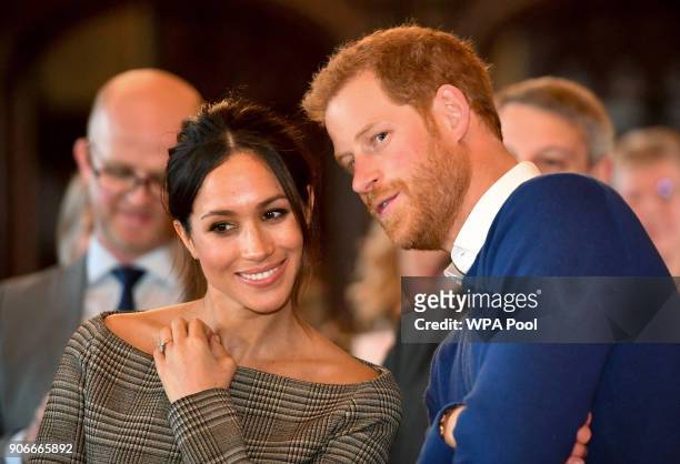 Prince Harry whispers to Meghan Markle as they watch a dance performance by Jukebox Collective in the banqueting hall during a visit to Cardiff...