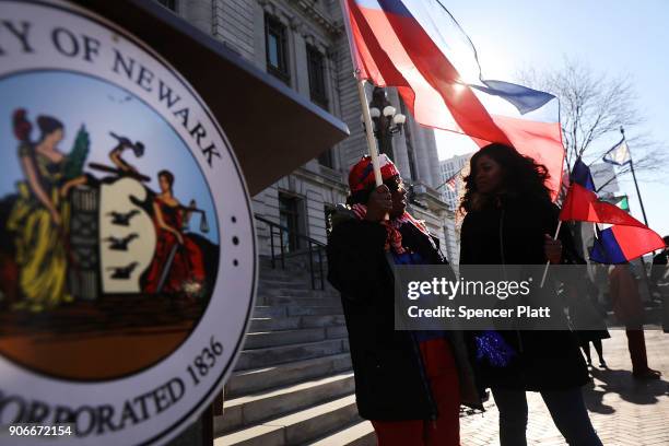 Waving the national flag of Haiti, students, activists and area politicians attend a unity rally on the steps of City Hall in downtown Newark in...