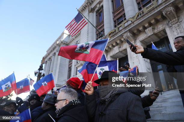 Waving the national flag of Haiti, students, activists and area politicians attend a unity rally on the steps of City Hall in downtown Newark in...