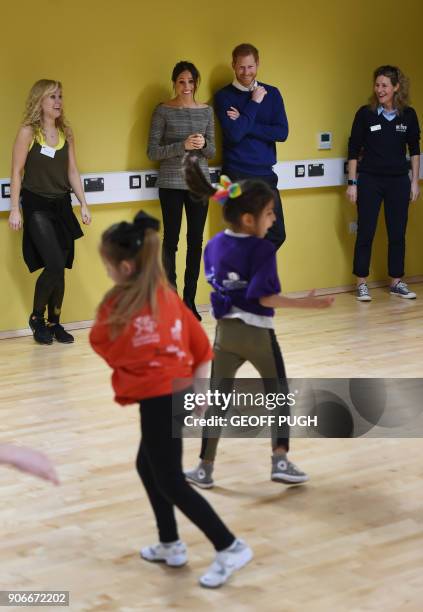 Britain's Prince Harry and his fiancée US actress Meghan Markle attend a street dance class during their visit to Star Hub community and leisure...