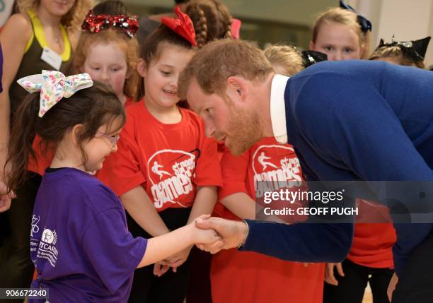 Britain's Prince Harry and his fiancée US actress Meghan Markle attend a street dance class during their visit to Star Hub community and leisure...