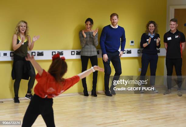 Britain's Prince Harry and his fiancée US actress Meghan Markle attend a street dance class during their visit to Star Hub community and leisure...