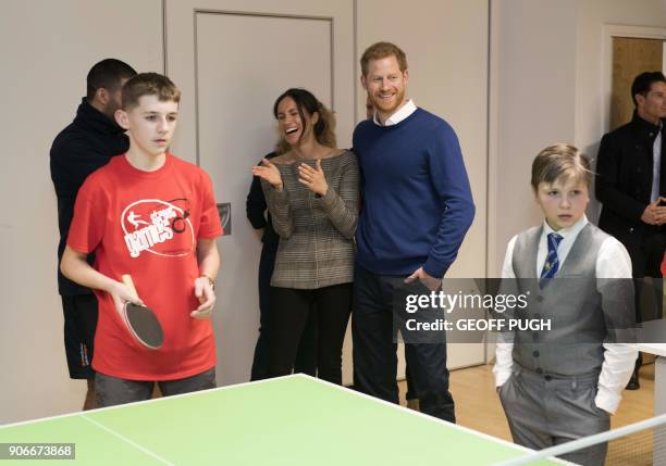 Britain's Prince Harry and his fiancée US actress Meghan Markle watch a game of table tennis during their visit to Star Hub community and leisure...