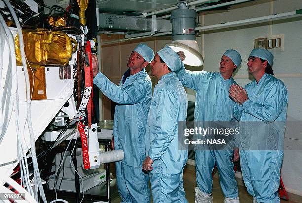 In the Solid Motor Assembly Building, Cape Canaveral Air Station, looking over the Inertial Upper Stage booster being readied for their mission are...