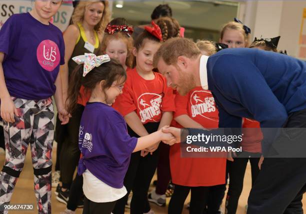 Prince Harry shakes hands with a little girl as he attends a street dance class during his visit to Star Hub on January 18, 2018 in Cardiff, Wales.