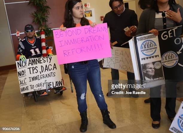 Chaunce O'Connor holds a sign that reads, "No Amnesty, No T.P.S., D.A.C.A "All immigrants have to obey the law," as Mariantonieta Chavez and others...